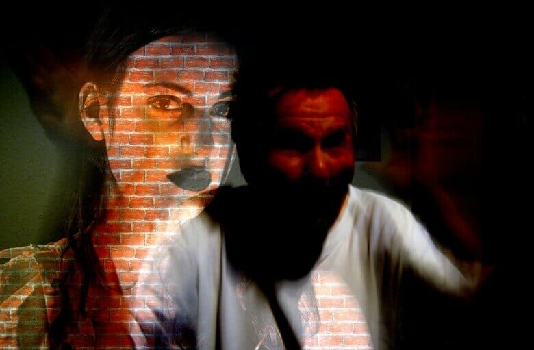 domestic violence visualization: woman over the wall behind the man