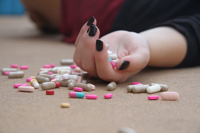 Female hand with pills in it and around