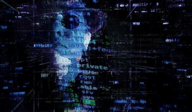 hacker's face behind computer code